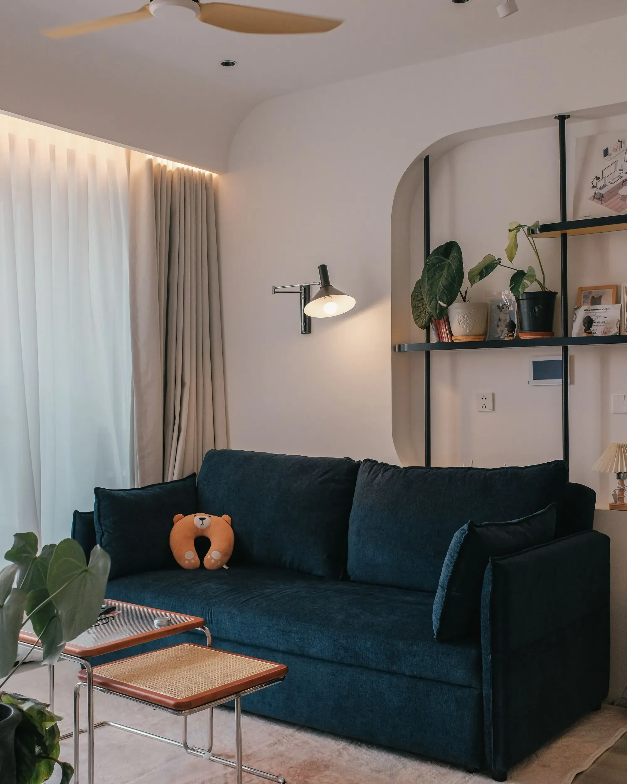 Salón de una vivienda reformada, con sofá, estanterías y luz natural